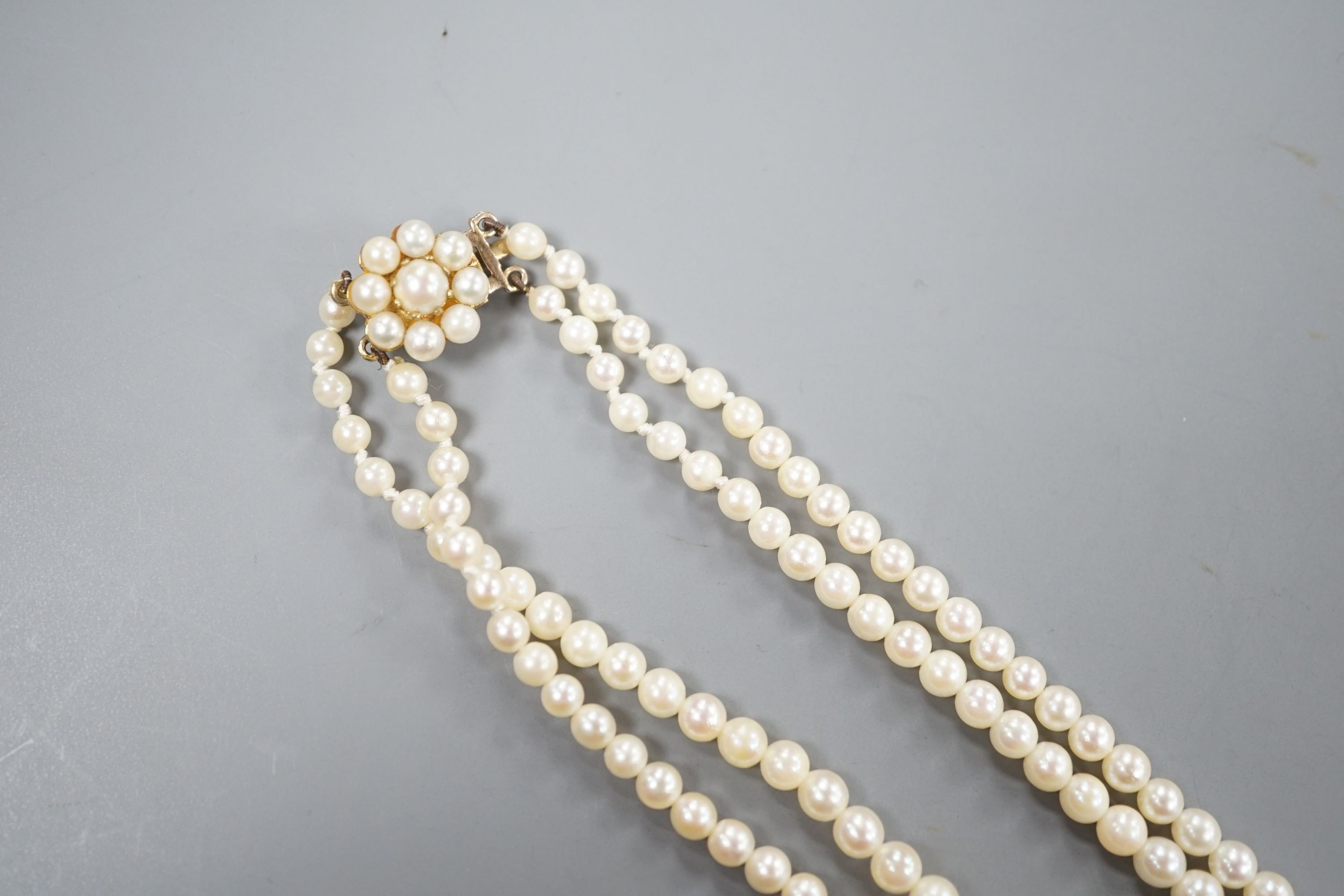 A double strand graduated cultured pearl necklace, with a 9ct and cultured pearl set clasp, 44cm.